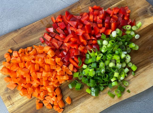 Gemüse für Bratreis schneiden Möhre, Lauch, Erbsen, Paprika anbraten