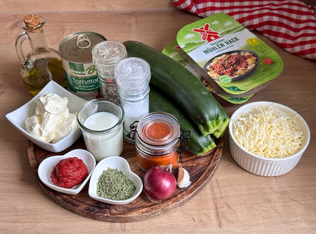 Low Carb Zucchini Lasagne Rezept Zucchini, Zwiebel, Salz, Pfeffer, Käse, Hackfleisch auf einem Holzbrett