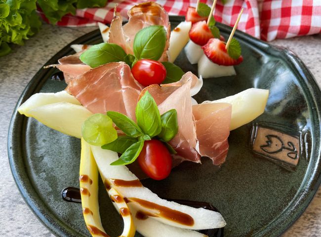 Melone mit Schinken anrichten Melone mit Schinken anrichten