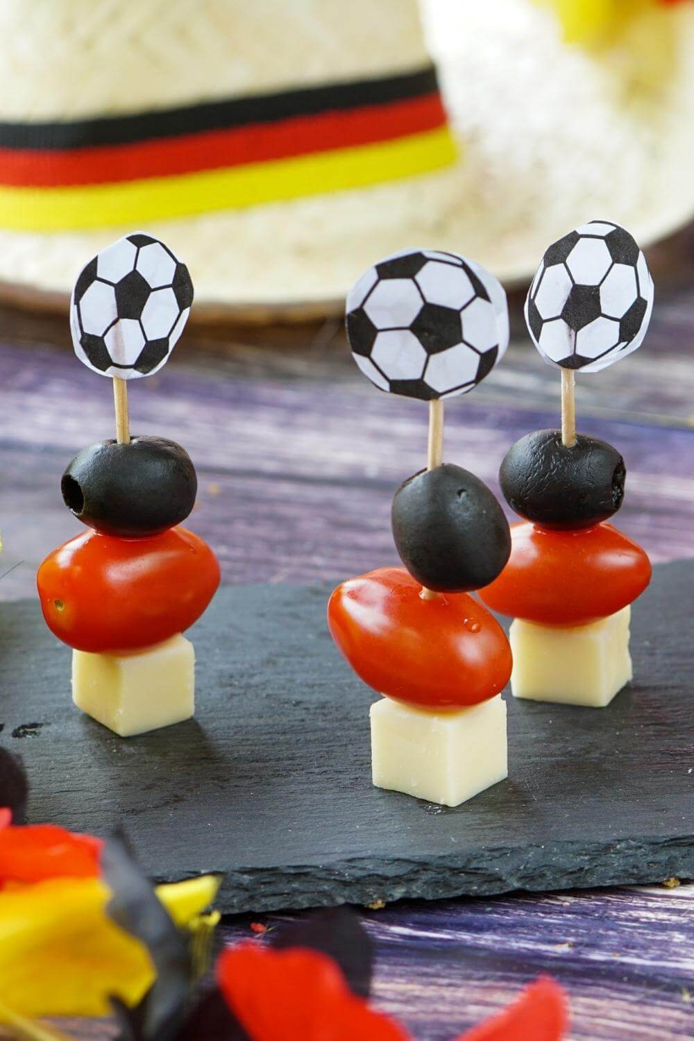 K&auml;sespie&szlig;e mit K&auml;sew&uuml;rfel, Mini-Tomate, schwarzer Olive auf einem Fu&szlig;balltopper